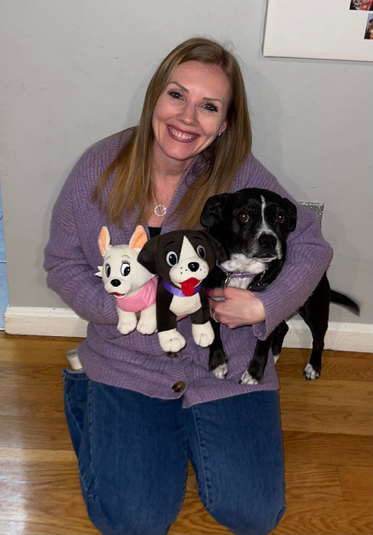 Christine Devane holding Sophie the dog alongside the Lola and Sophie character stuffed animals